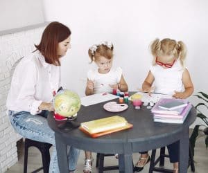 Canva Small kids painting in kindergarten under tutor supervision 300x250
